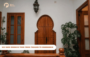 Merry Morocco tour card for Six Days Morocco Tour from Tangier to Marrakech showing a traditional riad interior with carved wooden Moorish door